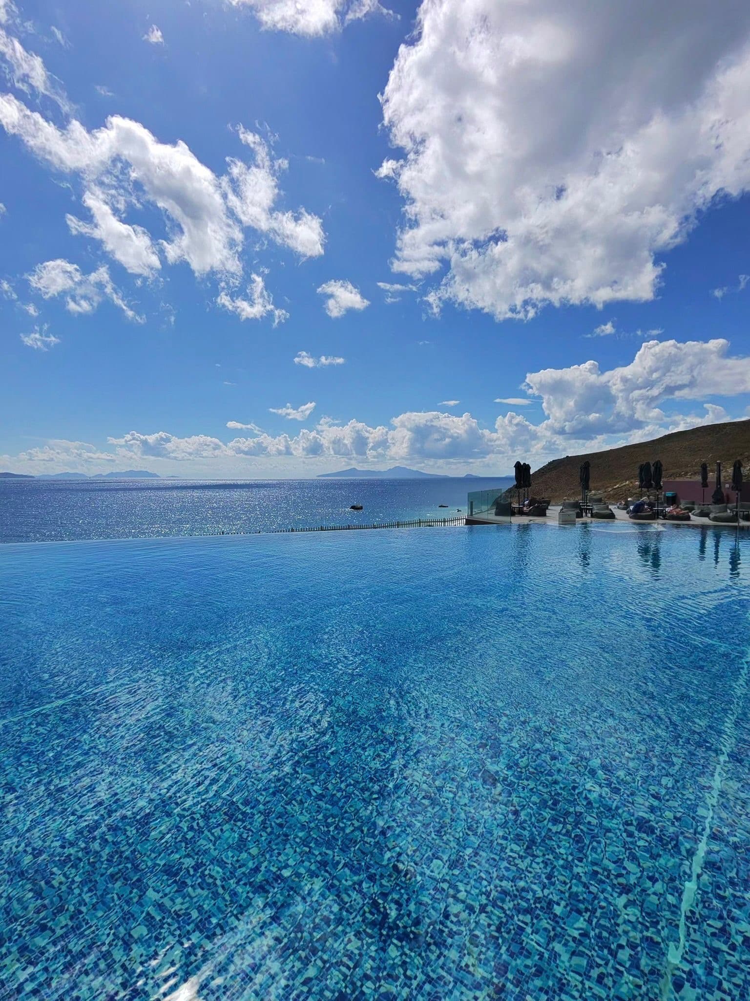 Infinity pool with dramatic sky over the sea